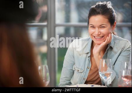 Woman smiling at a dining table. Stock Photo