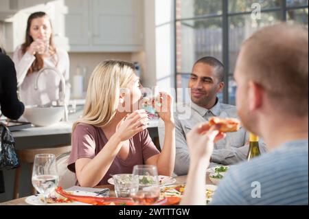 Friends enjoying a meal together indoors Stock Photo