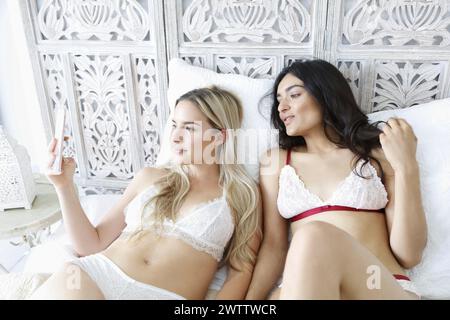 Two women lounging and taking a selfie Stock Photo