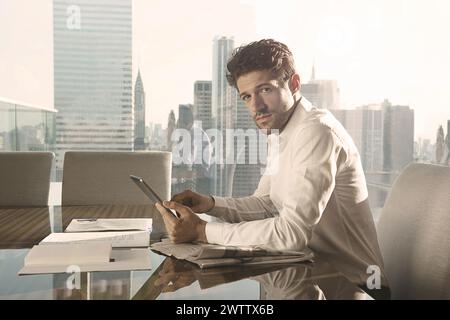 Man working on tablet in office with city view Stock Photo