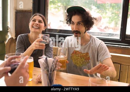Friends laughing and drinking in a pub Stock Photo