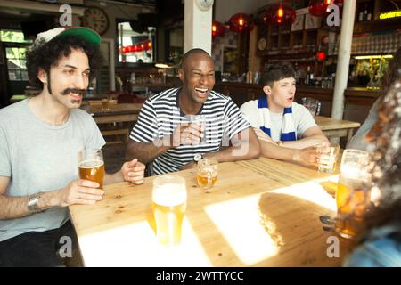 Friends laughing together at a bar Stock Photo