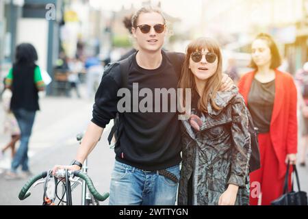 Couple walking with a bicycle on a city street Stock Photo