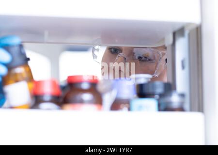 Curious scientist gazing at chemical samples in a laboratory fridge Stock Photo