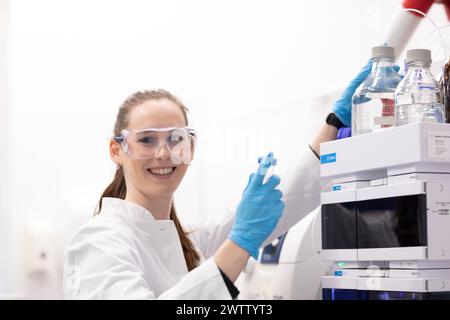 Smiling female scientist working with laboratory equipment. Stock Photo