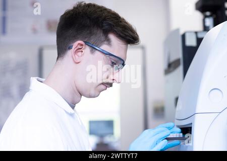 Young scientist analyzing samples in a laboratory setting. Stock Photo