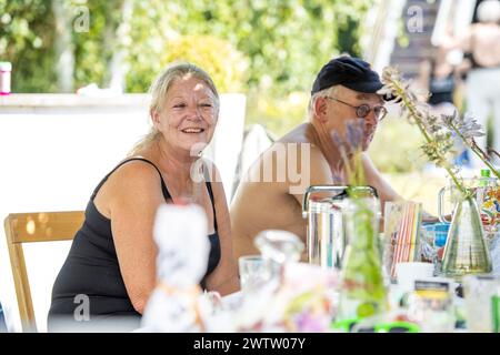 Elderly couple smiling at a table outdoors Stock Photo