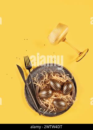 Table place setting and festive easter decor on yellow background Stock Photo