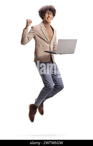 Excited young man jumping with a laptop computer isolated on white background Stock Photo
