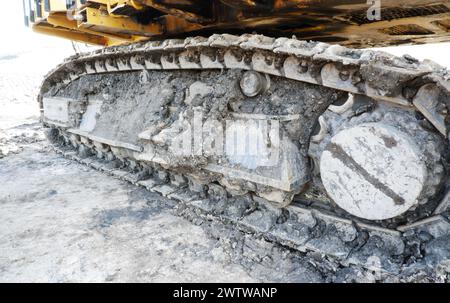 dirty excavator full of mud undercarriage or tracks, heavy equipment Stock Photo