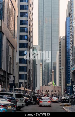 ABU DHABI, UAE - OCTOBER 18, 2021: Alley with skyscrapers and a mosque in Abu Dhabi downtown, United Arab Emirates. Stock Photo
