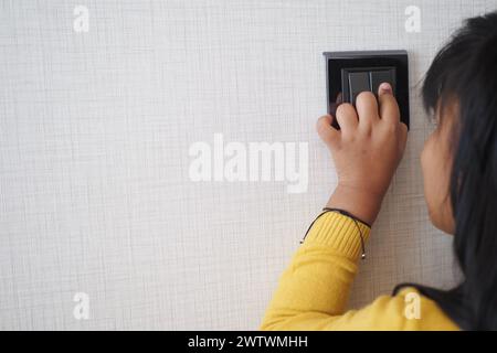 child finger turning on lighting switch with copyspace  Stock Photo