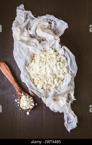 Raw curd cheese, grainy cottage cheese, ricotta, farmers cheese (Tworog) on dark background Stock Photo