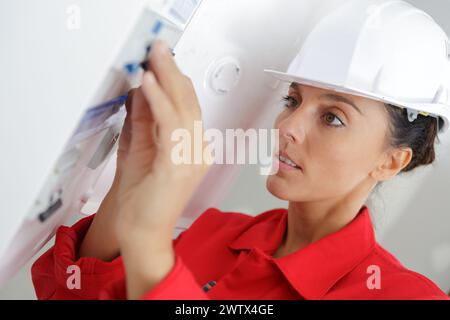 woman worker inspecting fuse board Stock Photo