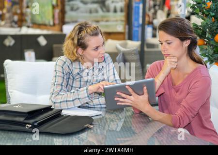 two female workers holding a tablet Stock Photo