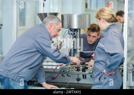 engineer and apprentices using automated milling machine Stock Photo