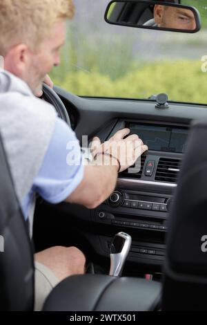 a man touching the car dashboard Stock Photo