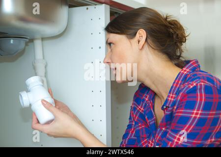 clever woman repairing her bathroom sink pipe Stock Photo