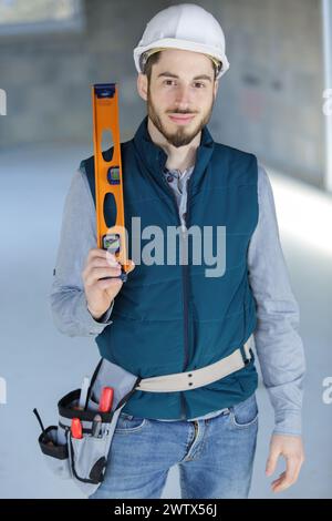 young male builder holding a spirit-level Stock Photo