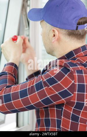 construction worker repairing window in house Stock Photo