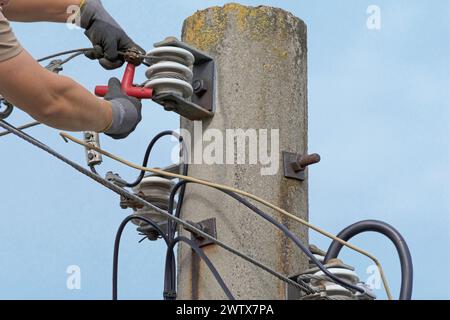 Power line on old power pole is being repaired Stock Photo