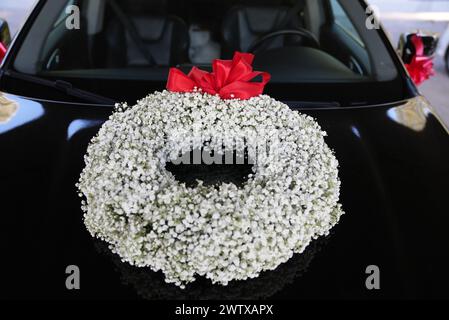 A wedding car decorated with a flower wreath Stock Photo