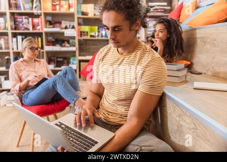 Portrait of young male student study in the library using laptop for researching online. Stock Photo