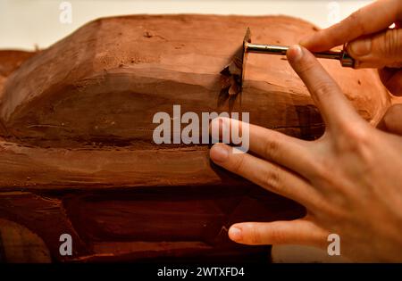 Designers work on the car's sculpture using carving tools. Adjust the surface of the model. in the automotive industry Stock Photo