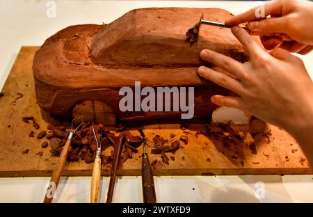 Designers work on the car's sculpture using carving tools. Adjust the surface of the model. in the automotive industry Stock Photo