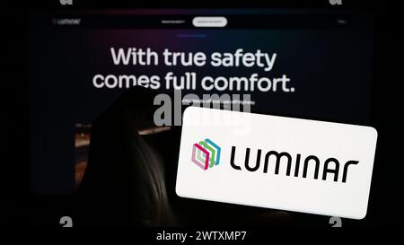 Person holding cellphone with logo of US lidar technology company Luminar Technologies Inc. in front of business webpage. Focus on phone display. Stock Photo