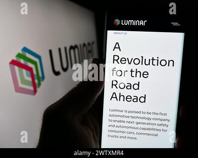 Person holding cellphone with webpage of US lidar technology company Luminar Technologies Inc. in front of logo. Focus on center of phone display. Stock Photo