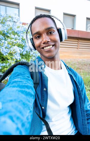 Vertical portrait of an African American teenager taking a selfie on the university campus. Stock Photo
