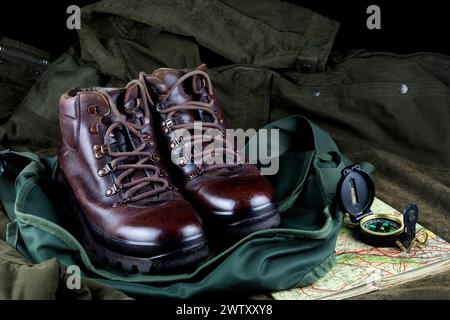 Old hiking boots with old map and compass on a game bag and outdoor field coat Stock Photo