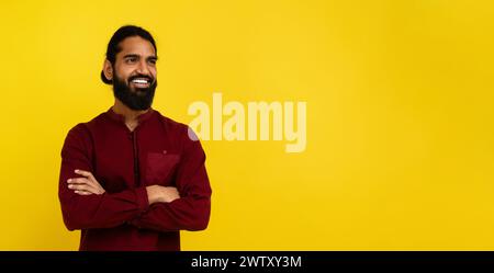 Confident indian guy looking at copy space on yellow Stock Photo