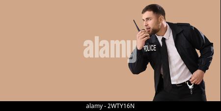 Male police officer with walkie-talkie on beige background with space for text Stock Photo