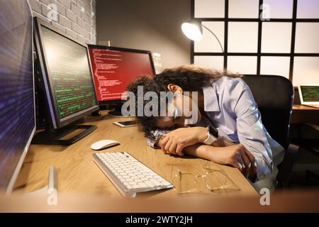 Female African-American programmer sleeping at table in office Stock Photo