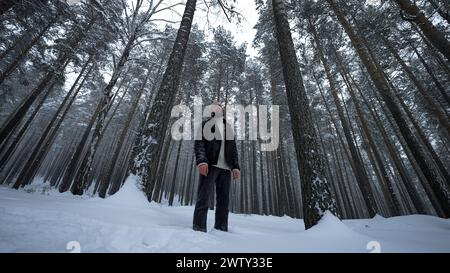 Stylish man poses in winter forest. Media. Shooting stylish man in winter forest. Fashion shooting of man in winter forest Stock Photo