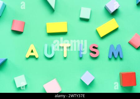 Word AUTISM with colorful blocks on green background Stock Photo