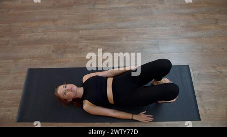 Sporty lady doing exercises and lying on floor at home. Media. Concept of active lifestyle and domestic training. Stock Photo