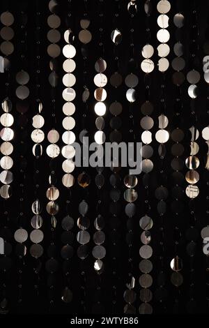 Abstract background with shimmering and shiny silver metal plates discs or sequins. Wall with a 3D abstract composition of mirror circles. Stock Photo