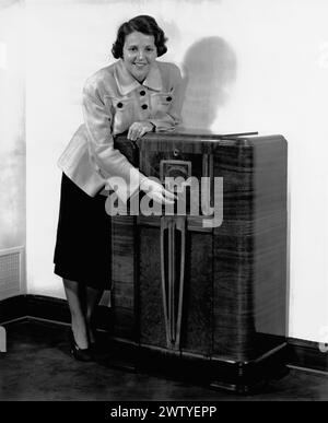 Actress and talent agent, Sue Carol leaning on a large radio cabinet Stock Photo