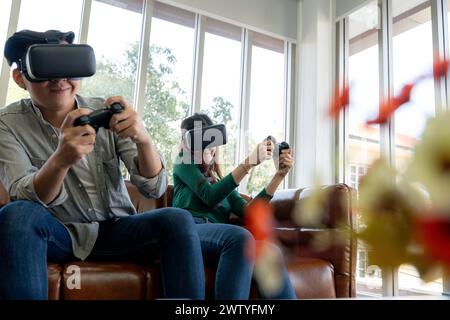 The young couple is having a great time playing VR games at home Stock Photo