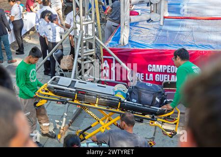 Oaxaca, Mexico - Emergency medical technicians bring in a stretcher and medical equipment in case it is needed during youth boxing matches. Stock Photo