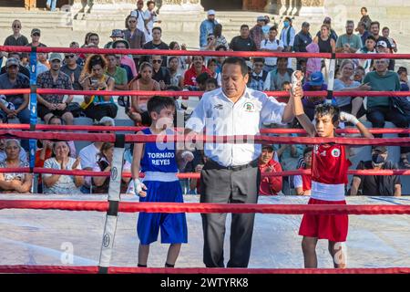 Oaxaca, Mexico - The referee declares the winner in a youth boxing match in the zocalo. Stock Photo