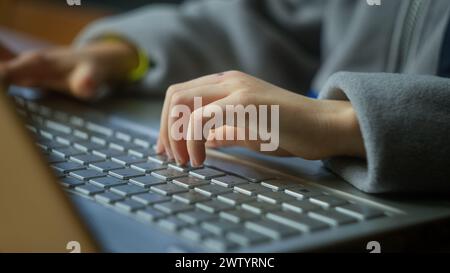 Close-up of kid hands typing laptop keyboard. Kid using computer for distance education online. Learning online at home. Stock Photo