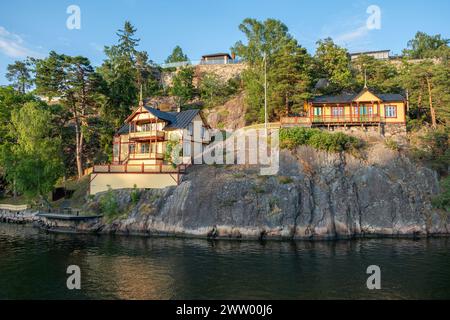 Traditional luxury villa at seaside of Sandhamn, Archipelago, Stockholm Sweden. Reflection of cottage in sea water, view of nature from cruise boat. Stock Photo