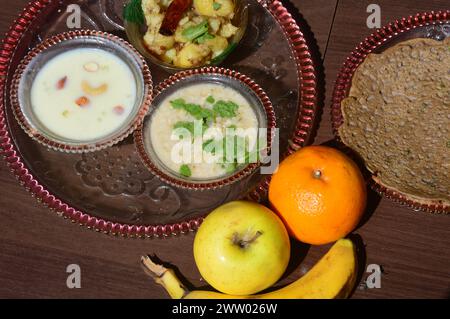 north indian brat ki thali,recipe (food after fast), sabudana (sago),bhresha kheer sweet and sour, spicy home style potatoes,suji chilla and  fruits. Stock Photo