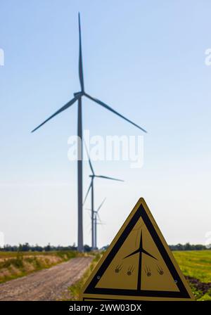 Wind Turbines with a caution sign warning of the dangers of approaching the turbine. Stock Photo