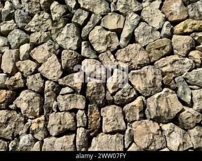 Texture of a rock wall built with the ancient dry stone technique. All stones are fitted together without concrete. Stock Photo