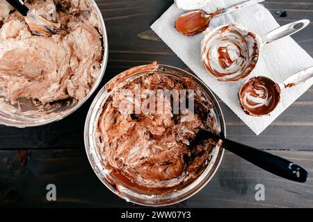 Vanilla Swiss Meringue Buttercream Mixed with Hazelnut-Cocoa Spread: Two mixing bowls filled with vanilla frosting mixed with hazelnut cream Stock Photo